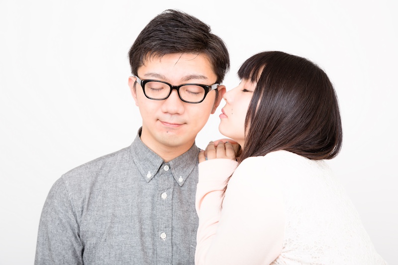 男性にキスする女性の画像